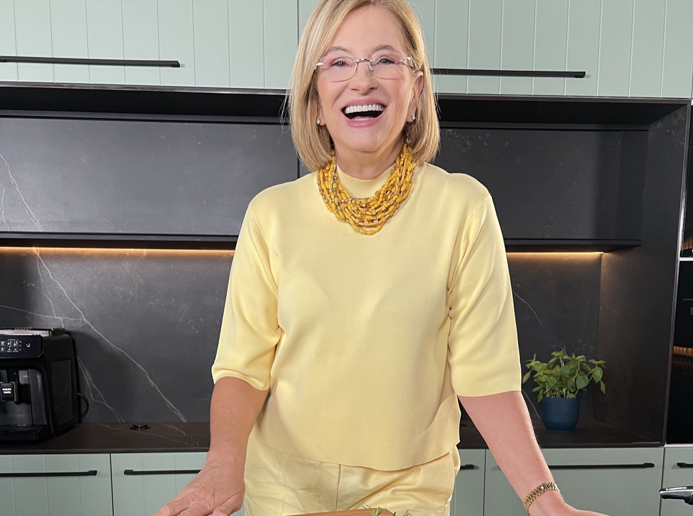 Sylvia Nogueira Cury, sorrindo, em uma cozinha